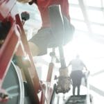 Sportowiec z protezą nogi ćwiczy na rowerze stacjonarnym w rehabilitacji